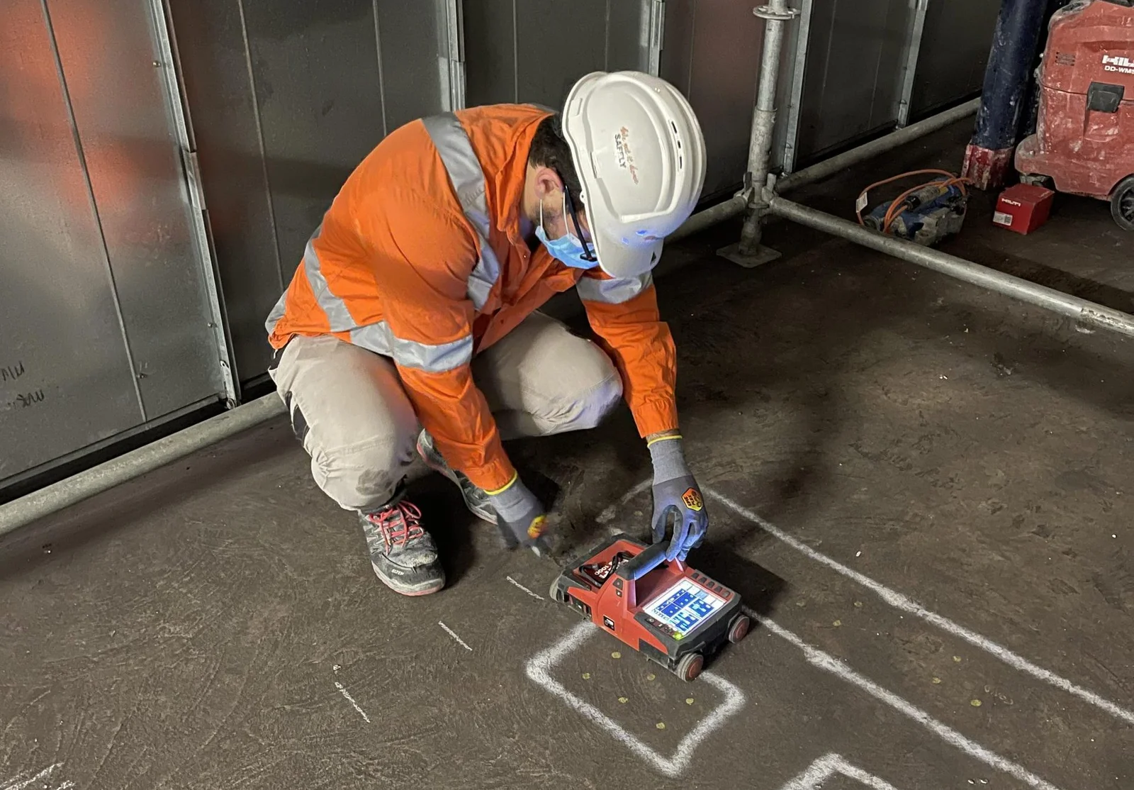 Operator running a ground penetrating radar unit across a concrete slab