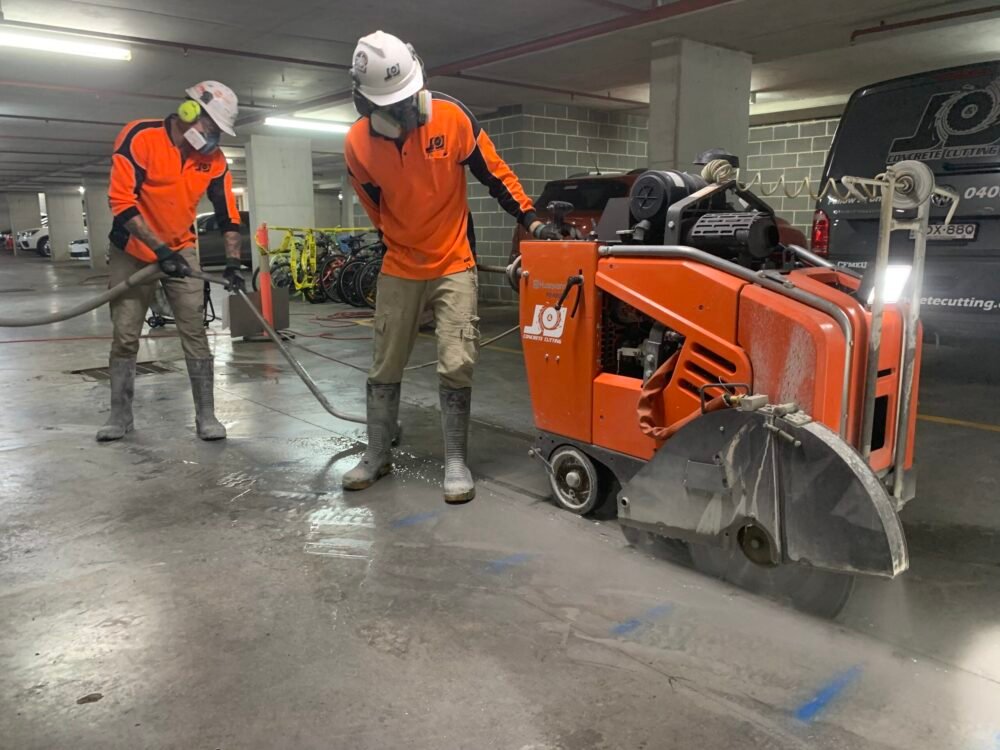 Walk-behind floor saw cutting a straight trench line into a concrete slab